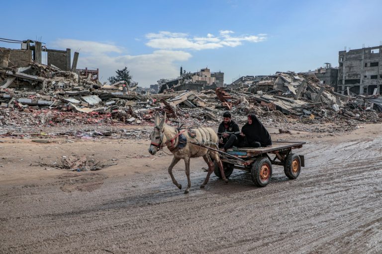 Un joven y su madre cruzan en una carreta tirada por un burro las calles destruidas del campo de Jabalia, en Gaza